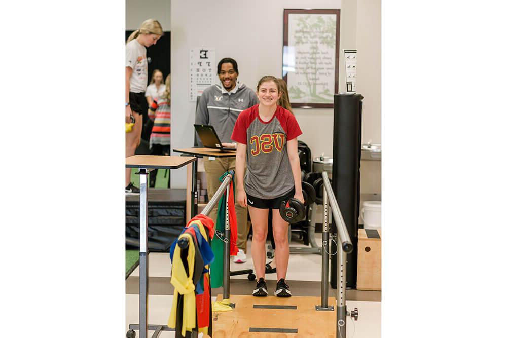 Physical therapy students practice helping patient learning to walk