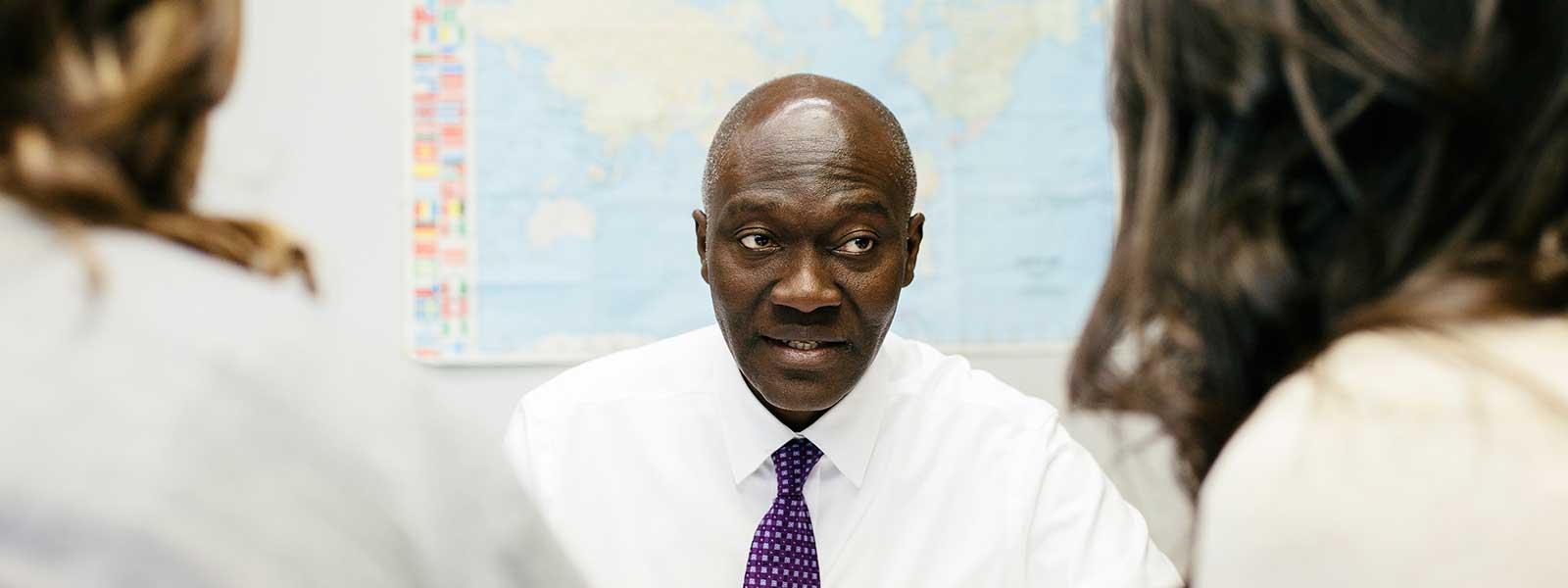 political science professor meets with two students in office